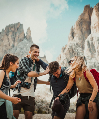 group of people laughing with mountains in the background