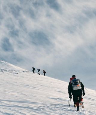 people climbing a snowy mountain