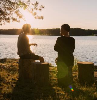 person standing on a rock in a body of water looking out over the mountains