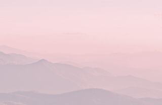 pink and purple early morning fog over hills and mountains