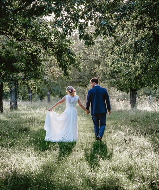 bride and groom holding hands in nature
